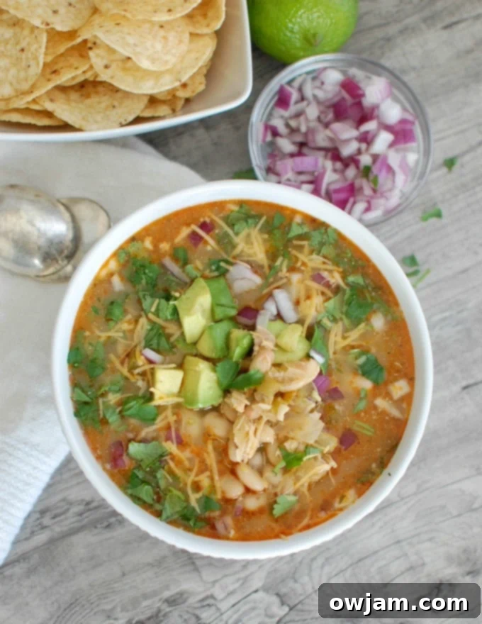 Slow Cooker White Chicken Chili with a spoon, showing its creamy texture.