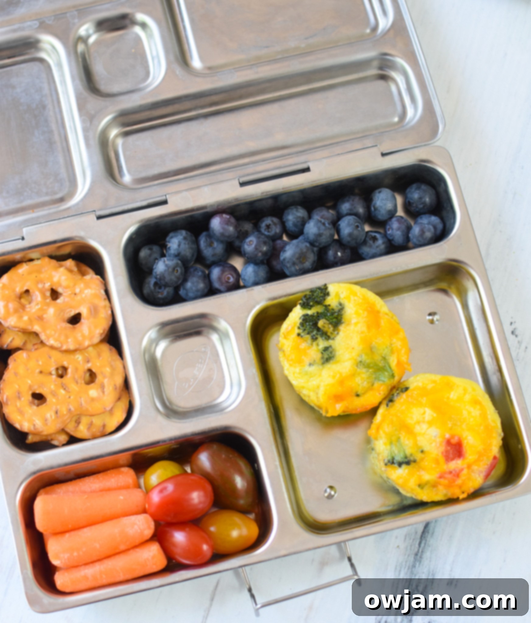 Broccoli Cheddar Cups packed in a lunchbox with other snacks, highlighting their portability.