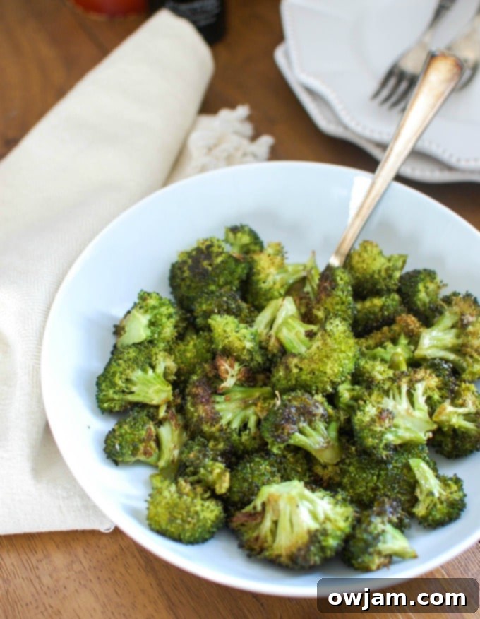 Roasted Broccoli Perfection 2 Roasted Broccoli in a bowl with a spoon.