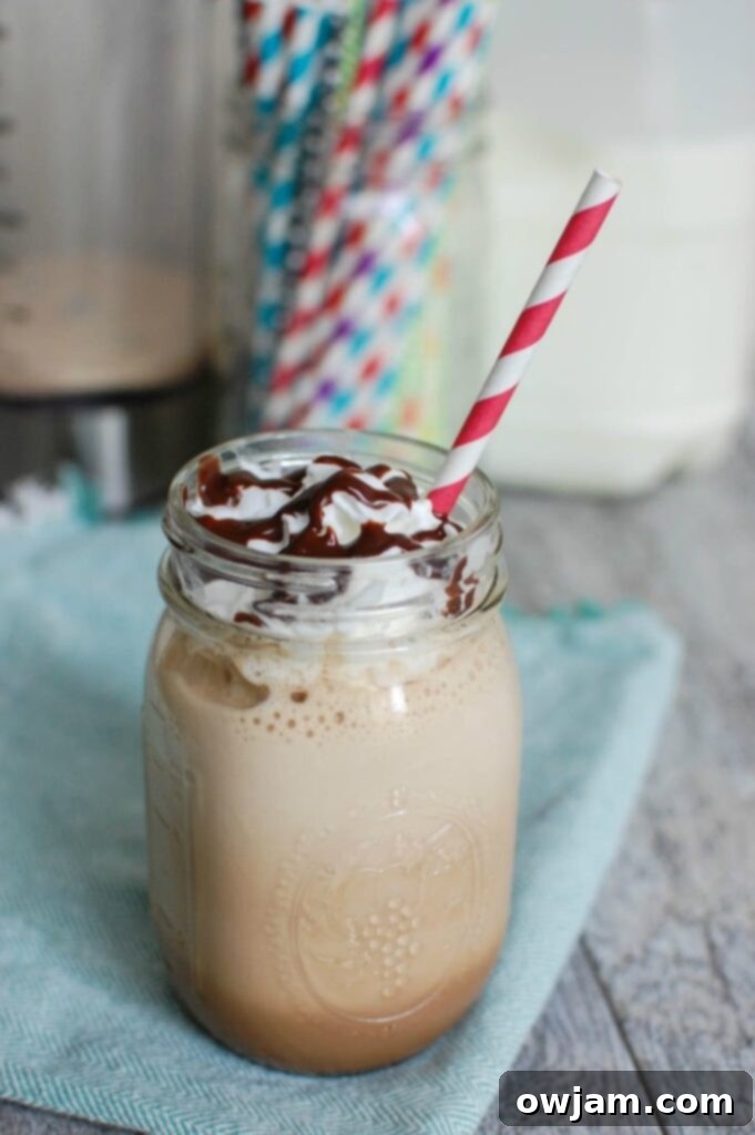 Homemade Mocha Frappuccino topped with whipped cream and chocolate drizzle, ready to be enjoyed.