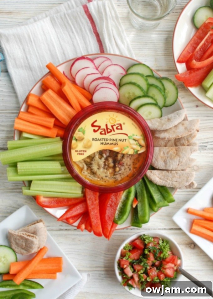 Close-up of Lebanese Style Hummus with fresh herbs and tomatoes, ready for dipping.