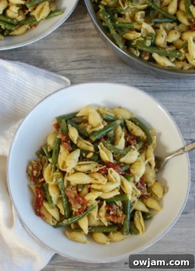 Pesto Pasta with Green Beans, Sun-dried Tomatoes and Toasted Pine Nuts with napkin, close-up shot of the delicious ingredients.