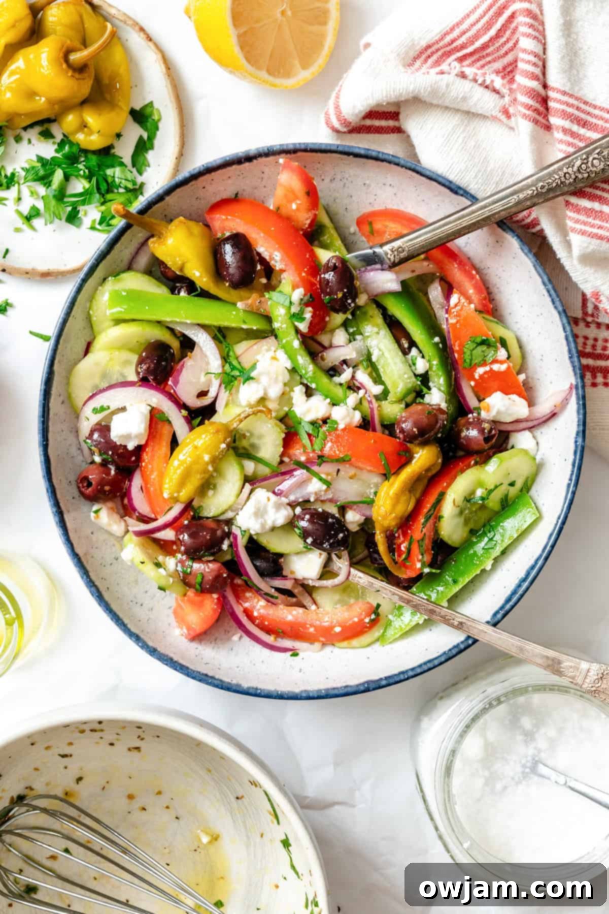 Rustic Greek Salad 4 Greek Village Salad served in a blue rimmed bowl with a fork, ready to be eaten