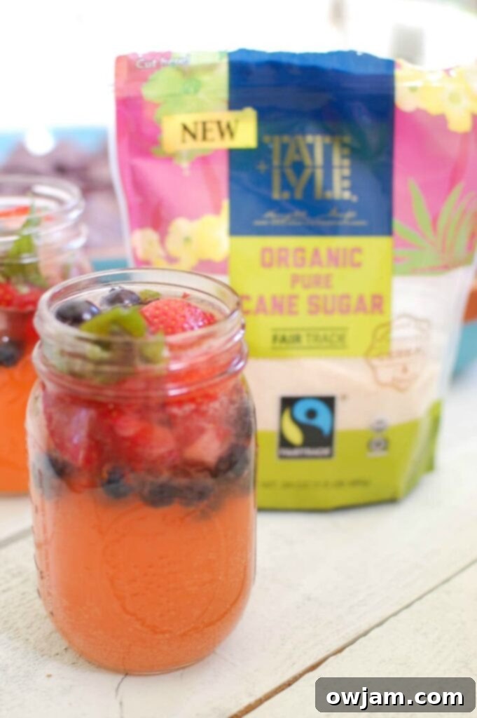 Strawberry Blueberry Lemonade Sparkler 5 Strawberry Blueberry Lemonade Spritzer in a mason jar on a rustic wooden surface, perfect for a BBQ or outdoor party
