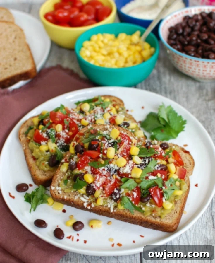 Spicy Southwest Avocado Toast 2 Two slices of Southwestern Avocado Toast topped with fresh ingredients like corn, black beans, tomatoes, and cilantro, ready to be enjoyed.