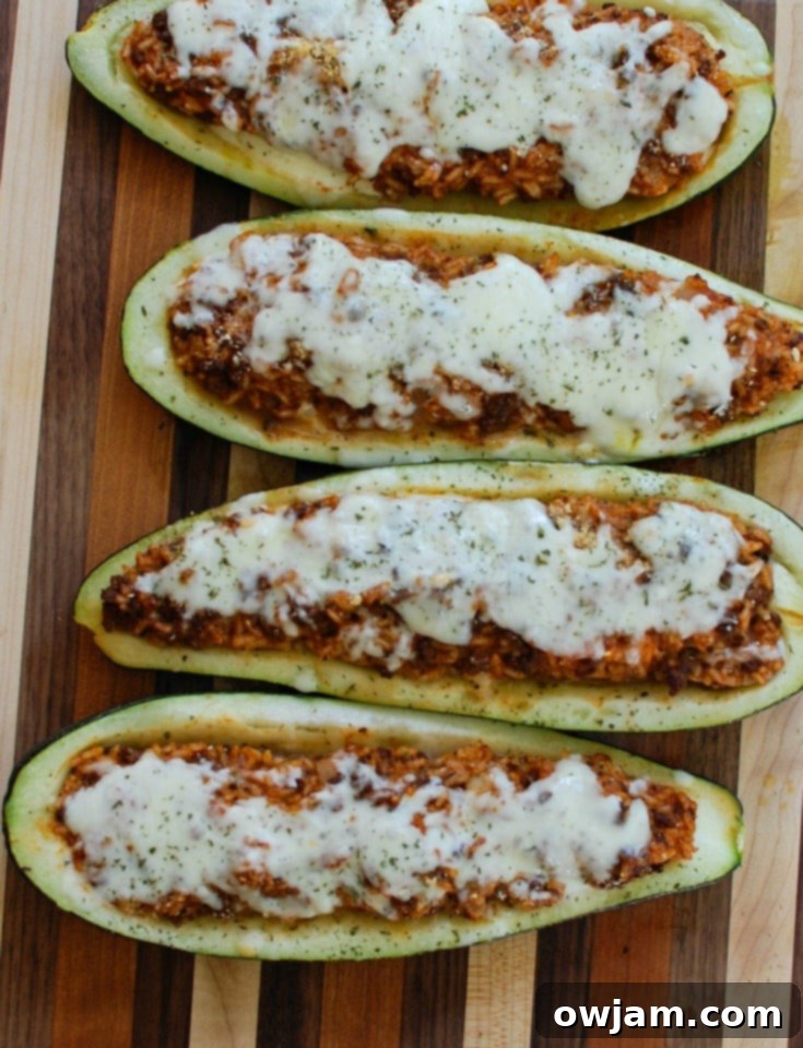 Vibrant Mediterranean Zucchini Boats 3 Scooped out zucchini halves arranged face down on a baking sheet, ready for baking before stuffing with Mediterranean meat and rice filling.