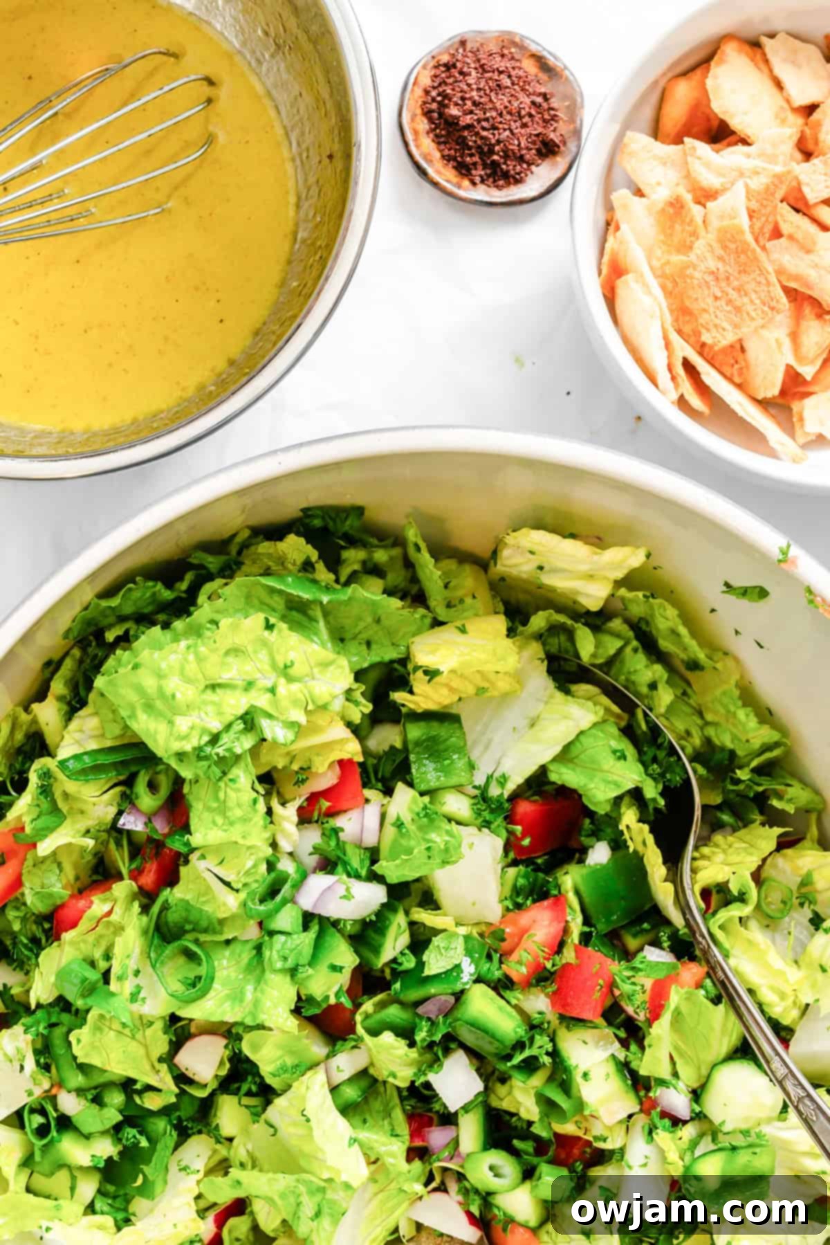 Fattoush Salad fully mixed with dressing and pita chips in a large bowl