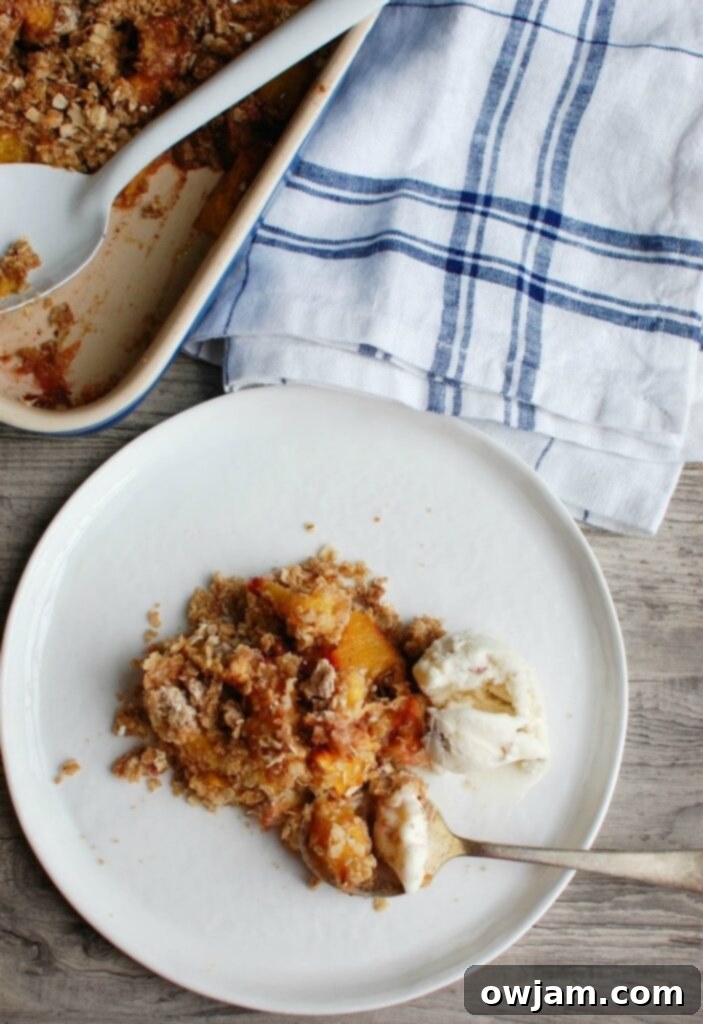 Peach Crisp is the best summer dessert. Fresh, warm peaches are topped with a crumbly topping and paired with ice cream. 