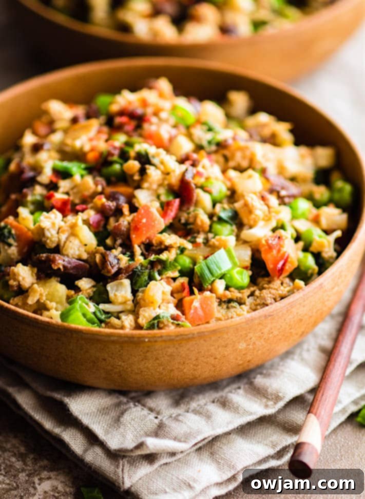 A bowl of Quick Pineapple Paleo Cauliflower Fried Rice, with visible cauliflower florets, pineapple chunks, and vegetables.