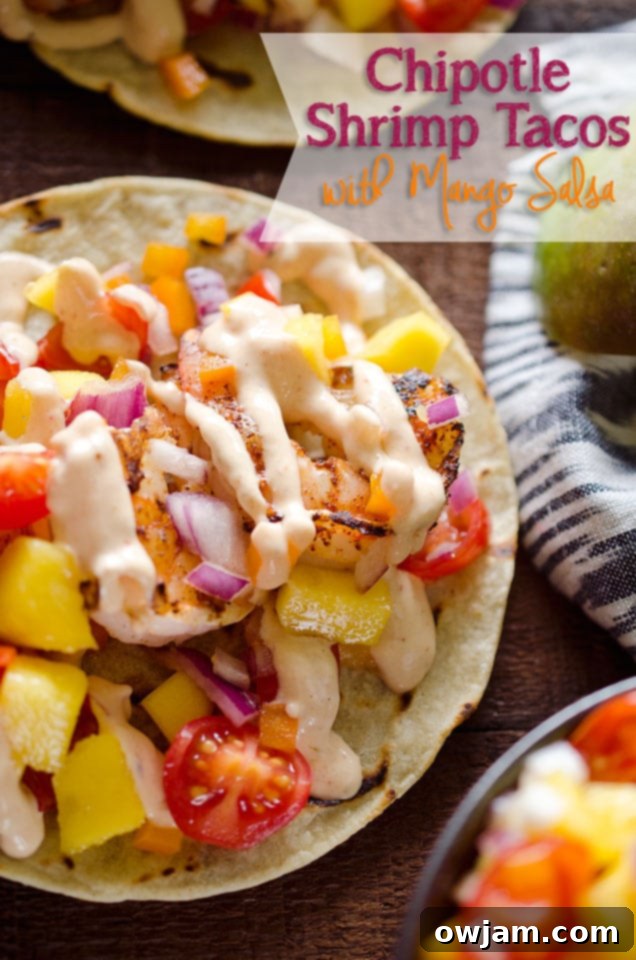 A serving of Chipotle Shrimp Tacos with Mango Salsa, garnished with fresh cilantro and lime wedges.