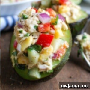 Tropical Tuna Avocado Boats 5 Tropical Tuna Stuffed Avocado on a cutting board with a napkin in the background