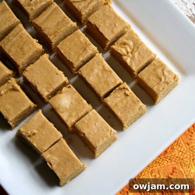 Easy Pumpkin Pie Fudge squares stacked on a white plate.