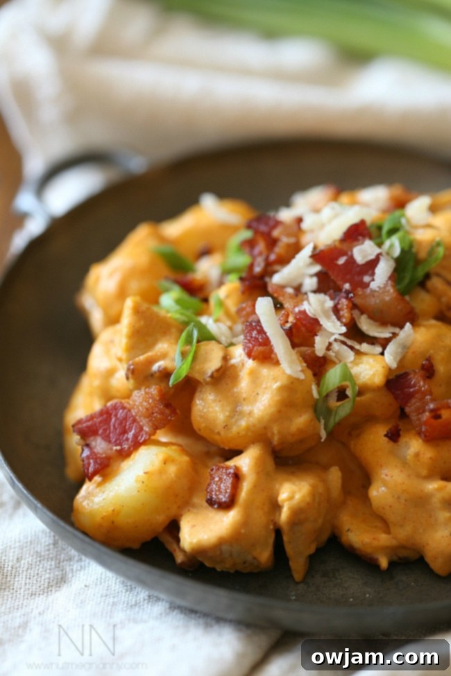 Chicken Bacon Pumpkin Gnocchi in a skillet with herbs.