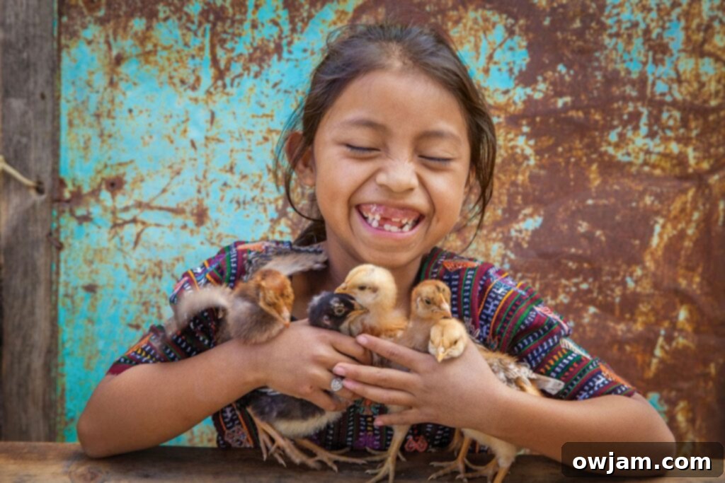 Yennifer holds baby chicks her family received as a part of the Gift Catalog program.