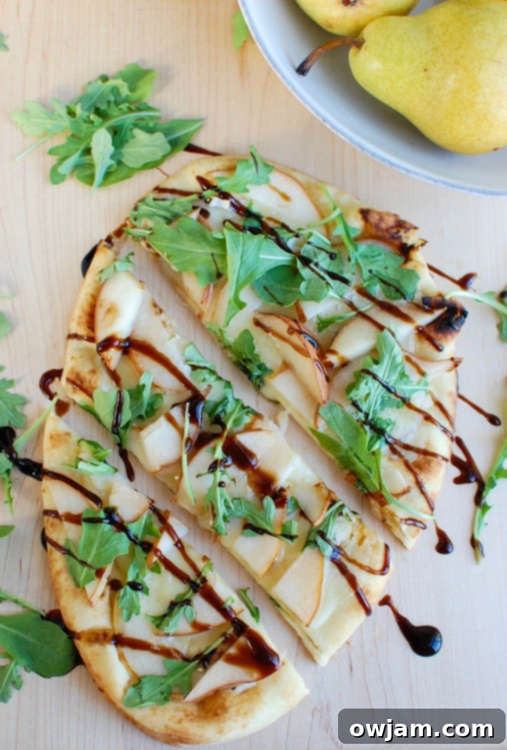 Warm Pear Brie Arugula Naan with balsamic glaze. A gourmet holiday appetizer.