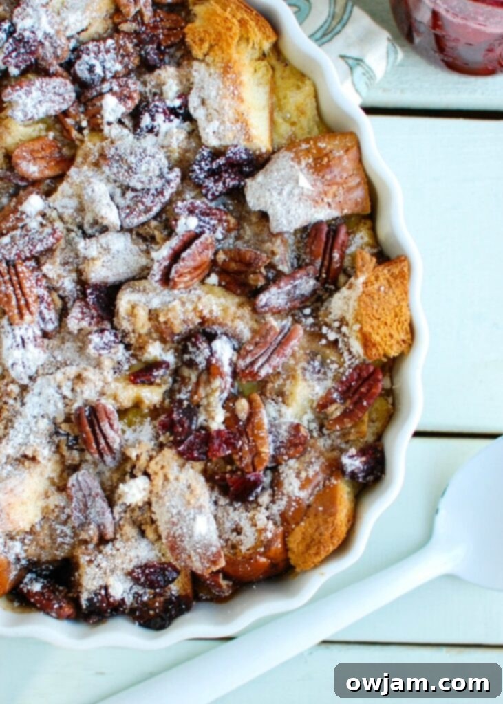 The ultimate Overnight Eggnog French Toast Bake with Cranberry Maple Syrup presented in a white baking dish, ready to be served for a delightful holiday breakfast.