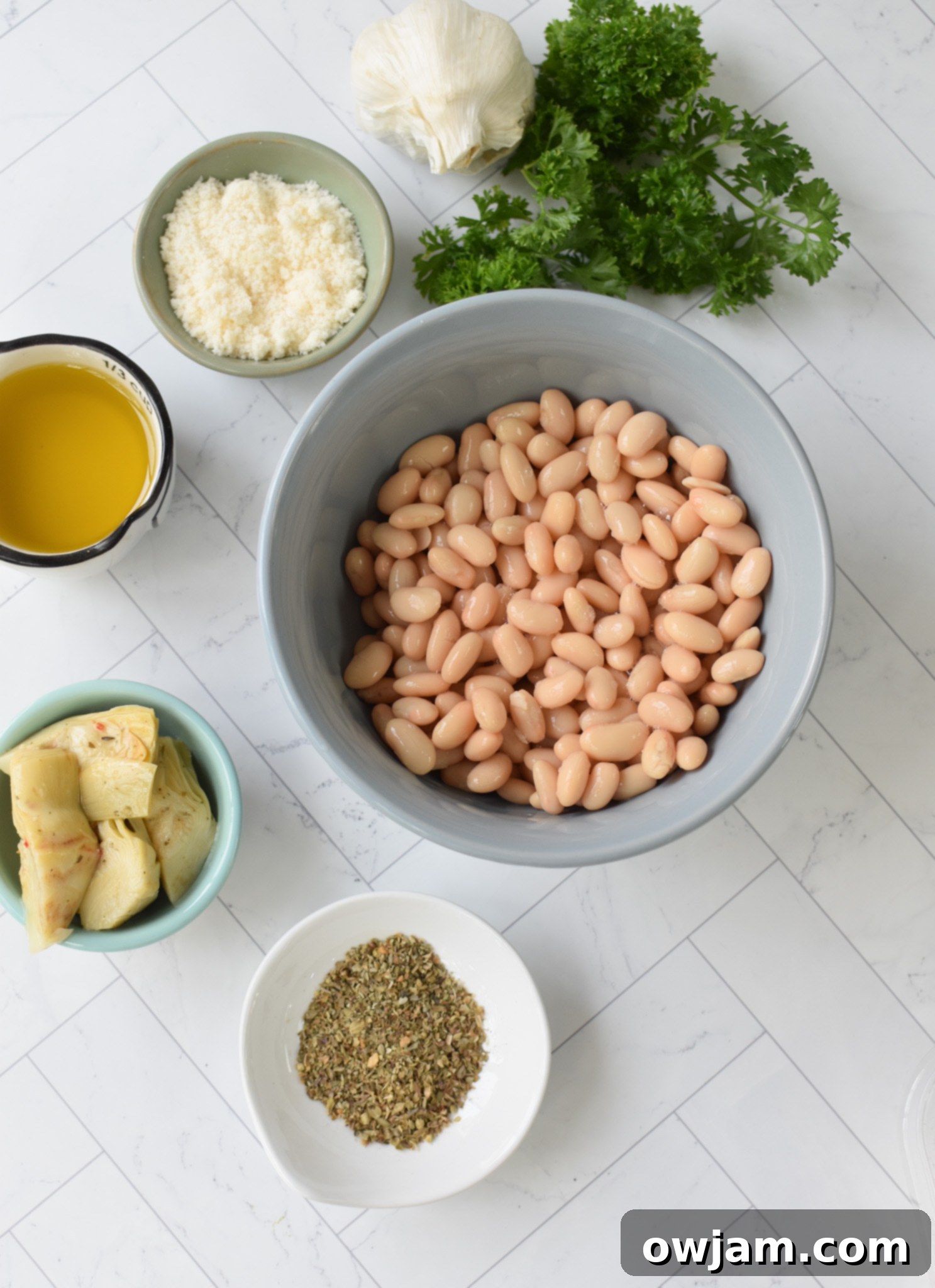 Creamy White Bean Artichoke Dip 3 Ingredients for White Bean Artichoke Dip laid out on a table.