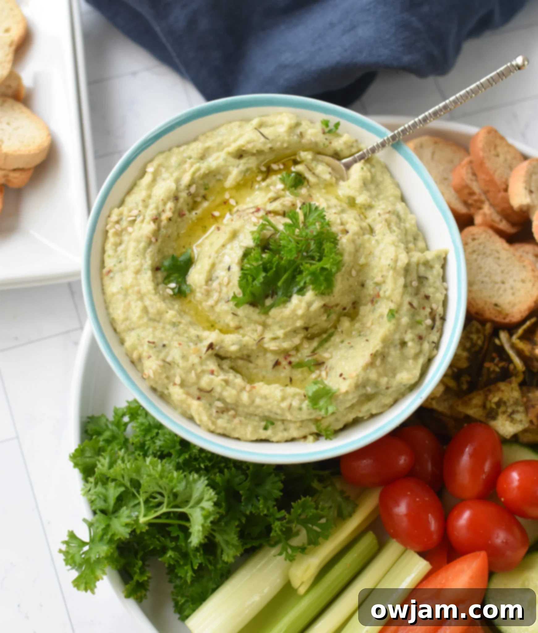 Creamy White Bean Artichoke Dip 4 White Bean Artichoke Dip served with a variety of crostini and fresh vegetables like carrots and cucumbers.
