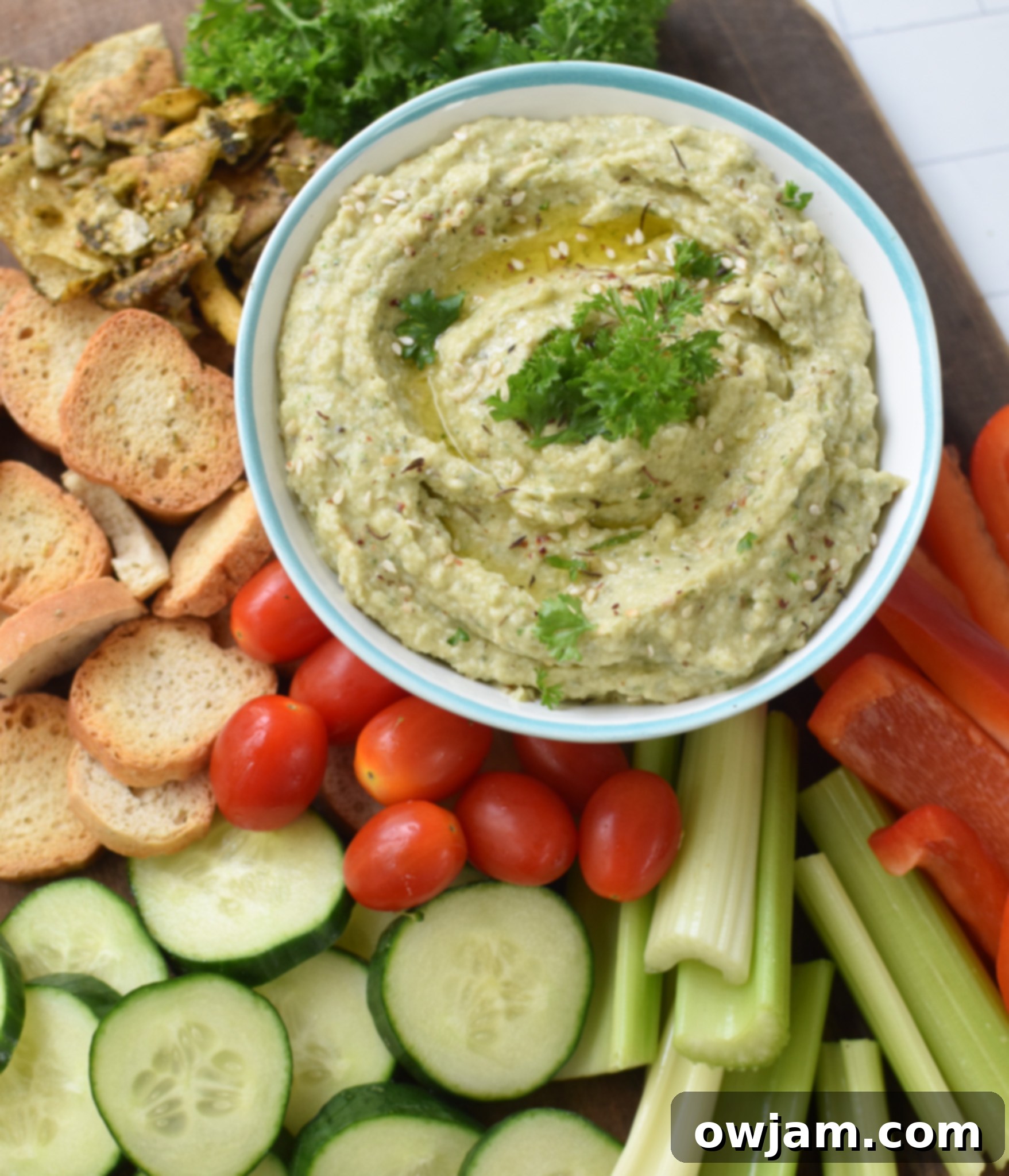 Creamy White Bean Artichoke Dip 7 White Bean Artichoke Dip served beautifully on a platter with various dippers for a gathering.