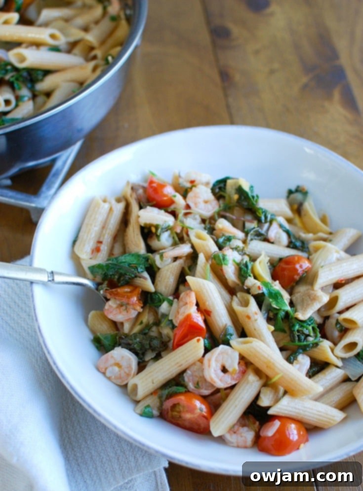 Zesty Shrimp Kale and Artichoke Pasta 4 A top-down view of Shrimp Kale Artichoke Pasta in a shallow bowl, garnished with fresh herbs, showcasing the vibrant colors and fresh ingredients of the dish.