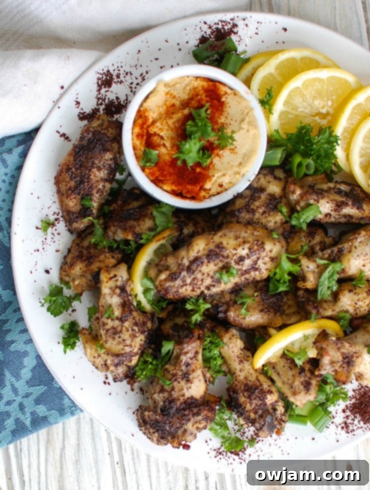Zesty Sumac Lemon Baked Chicken Wings 5 A large platter filled with golden-brown Sumac Lemon Baked Chicken Wings, ready to be shared.