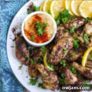 Zesty Sumac Lemon Baked Chicken Wings 6 A delicious platter of Sumac Lemon Baked Chicken Wings, garnished with herbs and lemon slices.