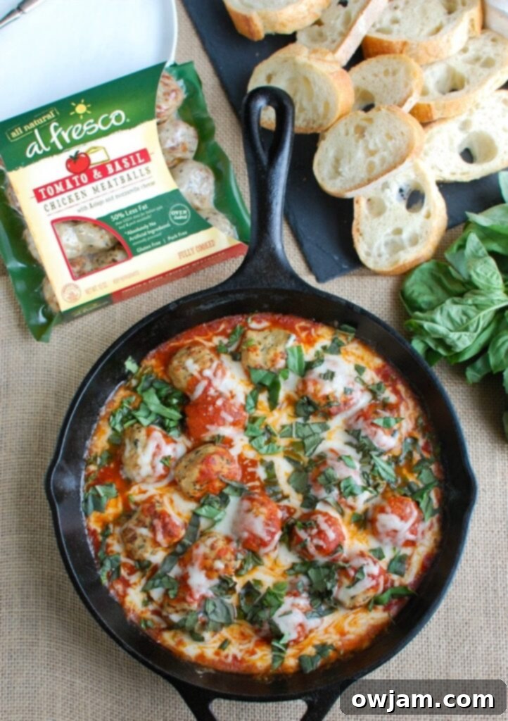 One-Pan Tomato Basil Meatballs 4 Serving suggestion for Skillet Tomato Basil Meatballs with a side of warm baguette slices, emphasizing its appeal as an easy party appetizer.