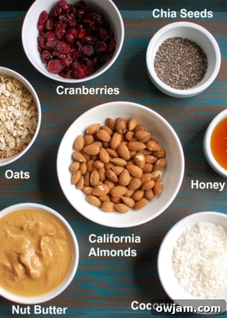 Almond Cranberry Recharge Bites 3 An array of fresh, natural ingredients for Cranberry Almond Energy Bites, including whole oats, roughly chopped almonds, vibrant dried cranberries, and shredded coconut, neatly arranged for preparation.