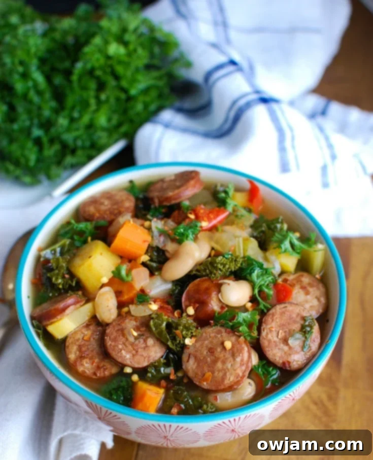 Tuscan Slow Cooker Sausage Kale White Bean Soup 2 A steaming bowl of Slow Cooker Sausage Kale White Bean Soup, garnished with fresh parsley and Parmesan cheese, showcasing its hearty texture and vibrant ingredients.