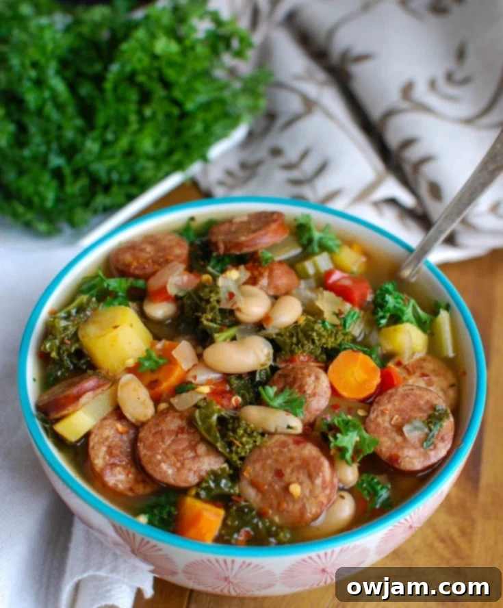 Tuscan Slow Cooker Sausage Kale White Bean Soup 3 Close-up of Slow Cooker Sausage Kale White Bean Soup in a bowl, showcasing the rich broth, tender beans, green kale, and sausage pieces.