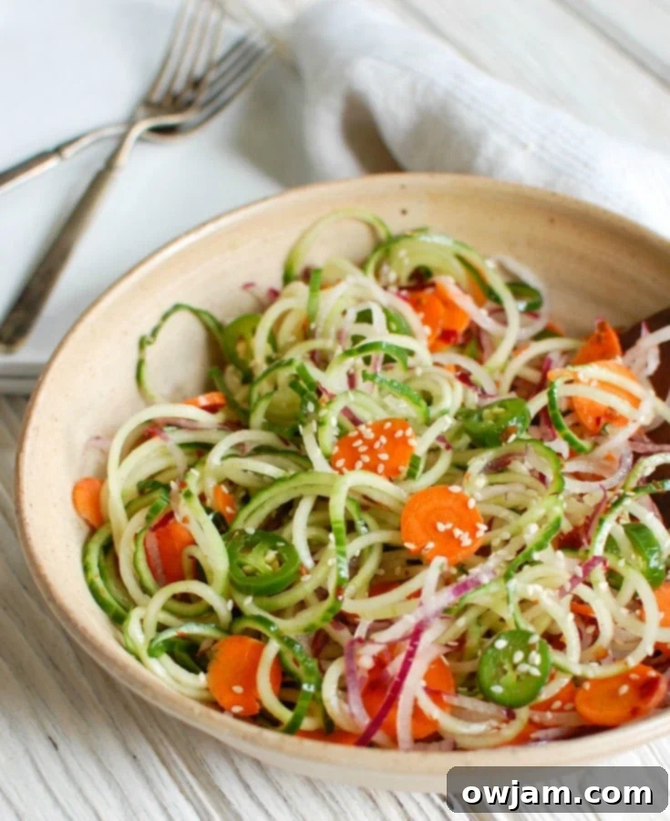 Asian Cucumber Noodle Salad is a light and healthy salad or side dish. Cucumber and red onion noodles, carrots and jalapeños are tossed with a light Asian dressing. 