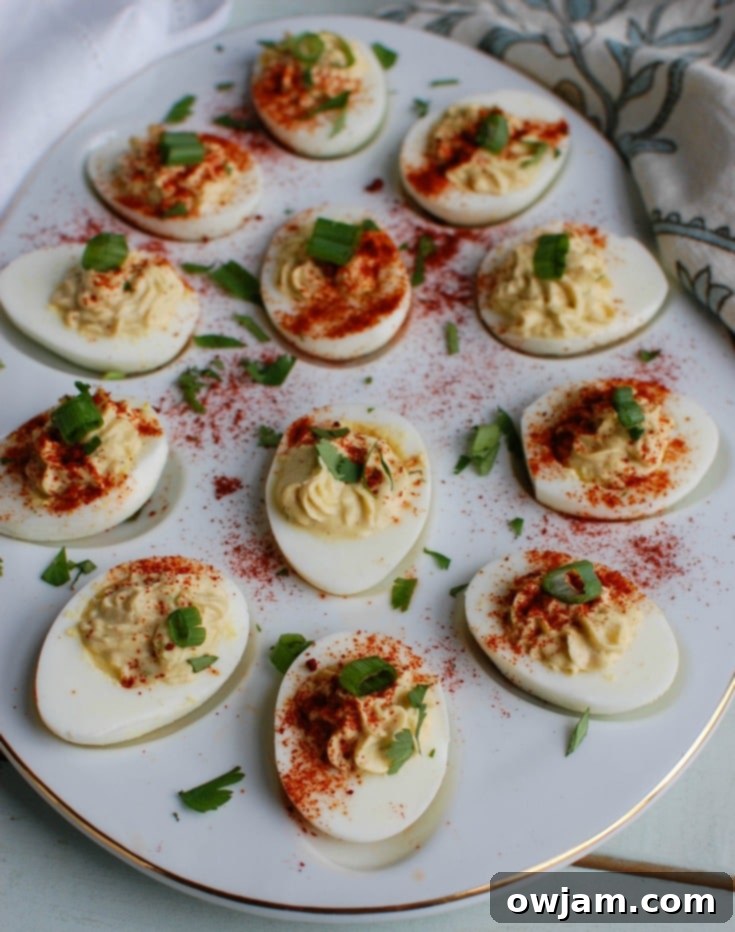Close-up of freshly prepared Southwestern Greek Yogurt Deviled Eggs, garnished with paprika, cilantro, and green onions, showcasing their creamy filling.