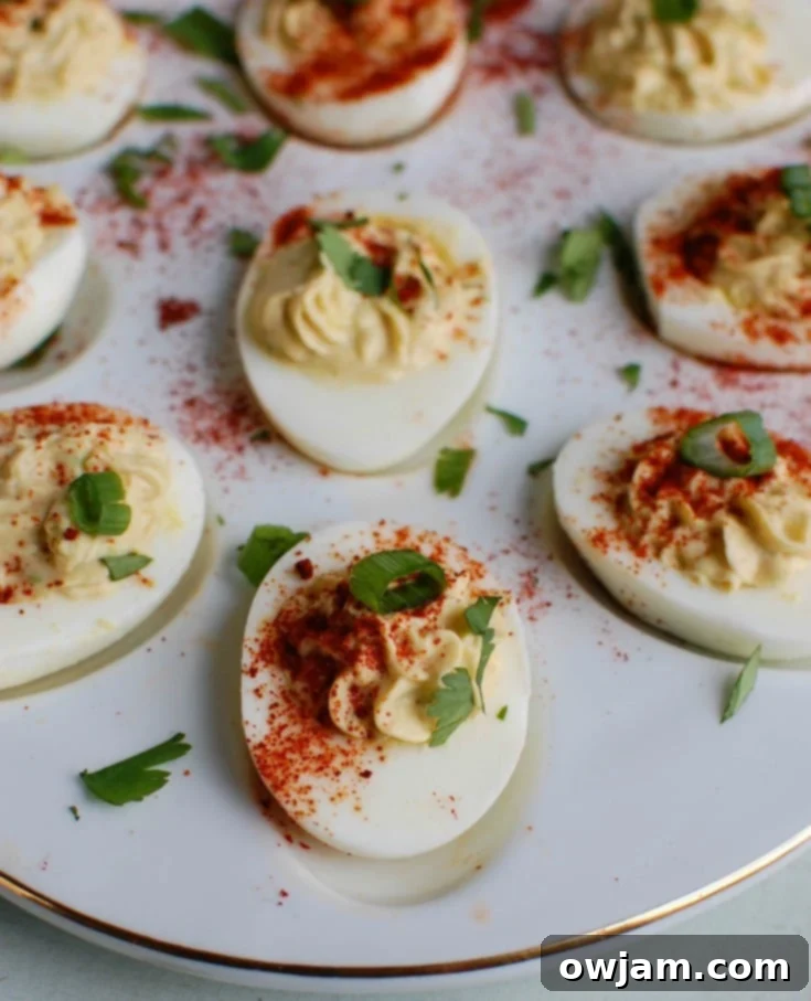 A vibrant platter of Southwestern Greek Yogurt Deviled Eggs, beautifully arranged and garnished with fresh cilantro, ready to be served at a gathering.