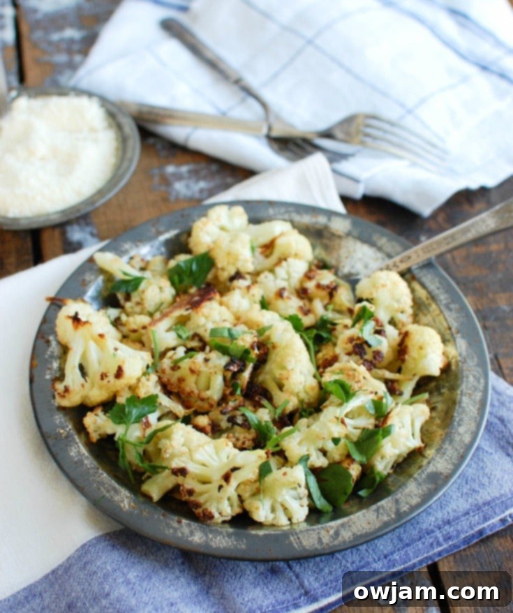 Crispy Parmesan Garlic Cauliflower 5 A bowl of hot, flavorful Roasted Parmesan Garlic Cauliflower, generously sprinkled with fresh parsley, ready to be enjoyed as a comforting and healthy dish.