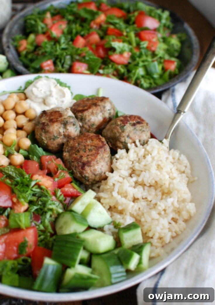 Mediterranean Baked Turkey Meatballs in a bowl, garnished with fresh herbs.