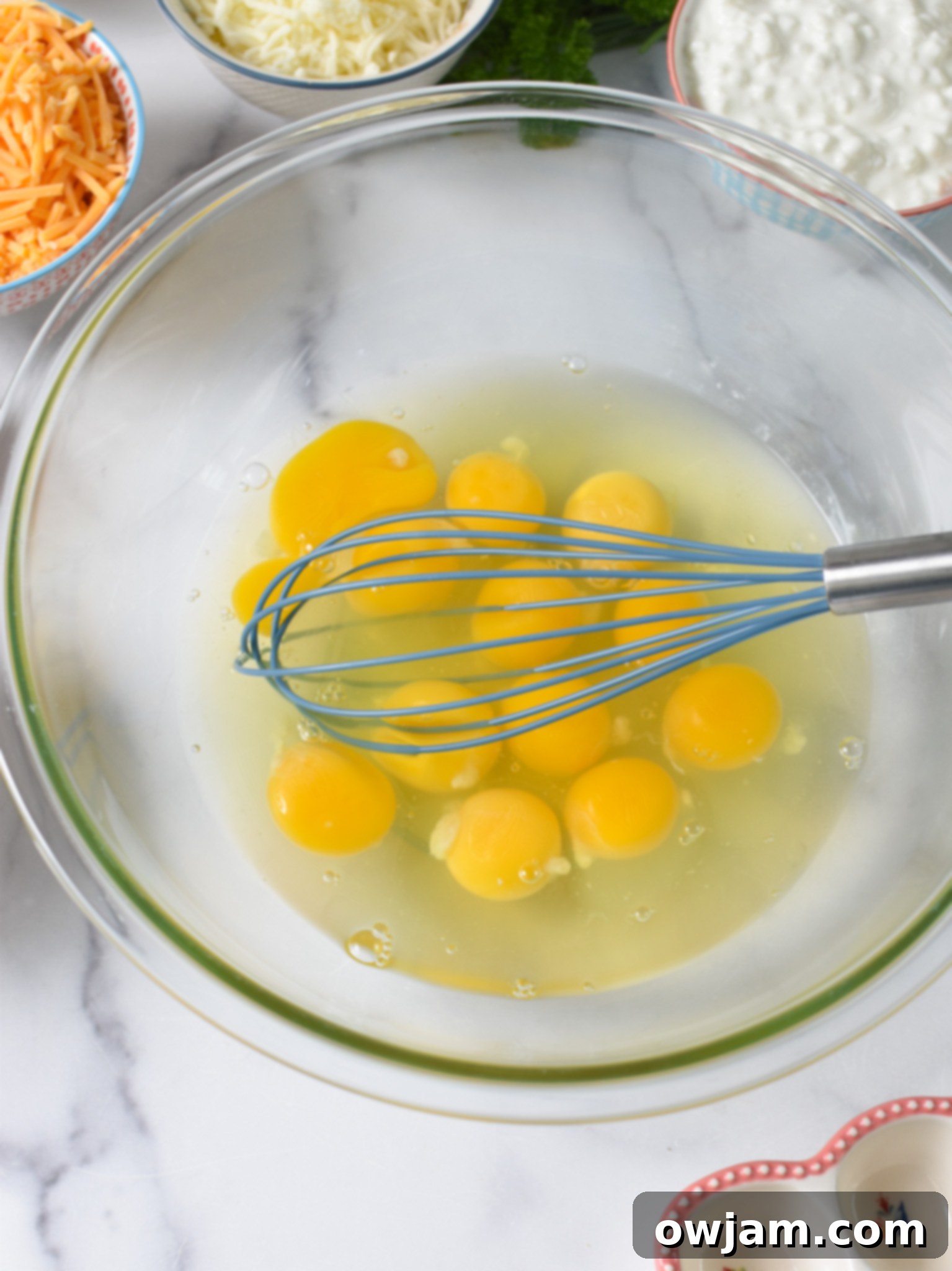 Southwest Sunrise Bake 8 Cheese and Sausage Baked Eggs eggs getting whisked.