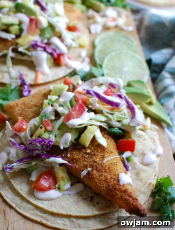 Easy Fish Tacos with Spicy Pineapple Salsa is a quick and easy meal that doesn't lack flavor! These are the perfect way to mix up taco night with baked breaded cod tacos topped with a spicy pineapple salsa and a spicy slaw.