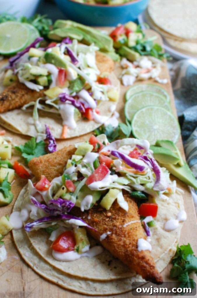 Easy Fish Tacos with Spicy Pineapple Salsa is a quick and easy meal that doesn't lack flavor! These are the perfect way to mix up taco night with baked breaded cod tacos topped with a spicy pineapple salsa and a spicy slaw.