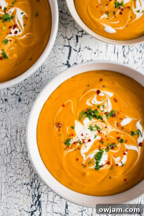 Creamy red lentil and carrot soup with curry spices, garnished with fresh cilantro.