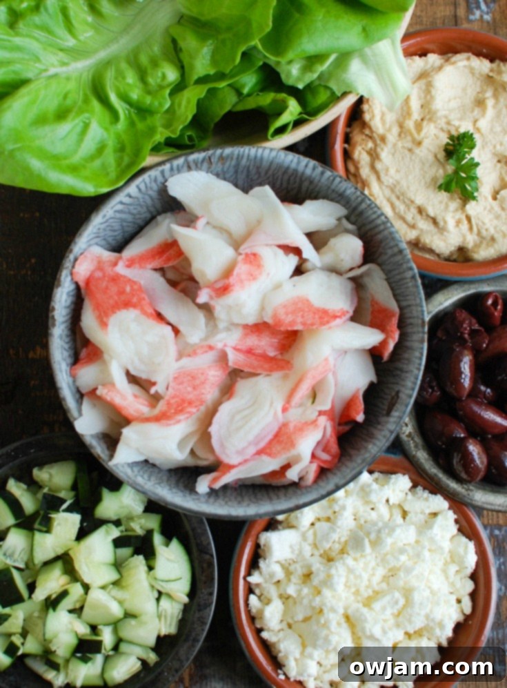 Three Mediterranean Surimi Lettuce Wraps arranged on a wooden board, showcasing the fresh and colorful filling.