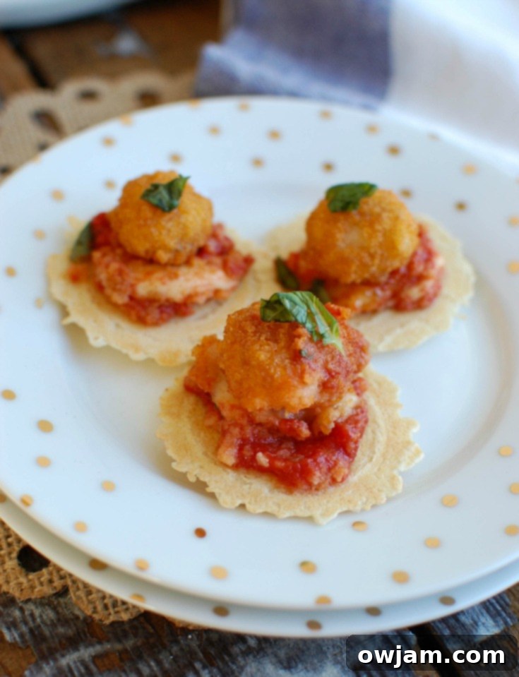 Close-up of Tomato Basil Mozzarella Popcorn Shrimp Bites, showing melted cheese and fresh basil atop crispy shrimp.