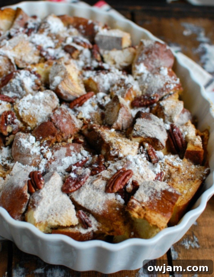 Festive Overnight Gingerbread French Toast Casserole 2 Delicious Overnight Gingerbread French Toast Casserole ready to be served, topped with powdered sugar and pecans.