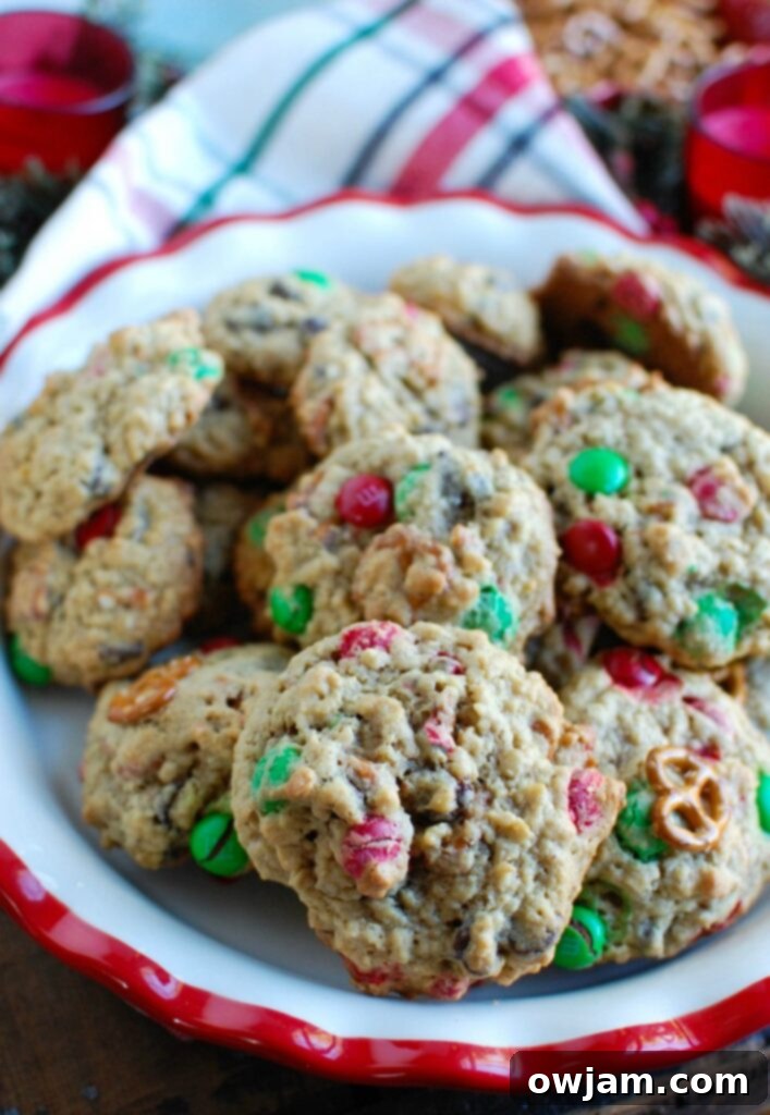 Delicious Peanut Butter Pretzel Chocolate Chip Cookies piled high, showing their rich texture, crunchy pretzels, colorful M&Ms, and melted chocolate chips. Perfect for holidays or any treat time.
