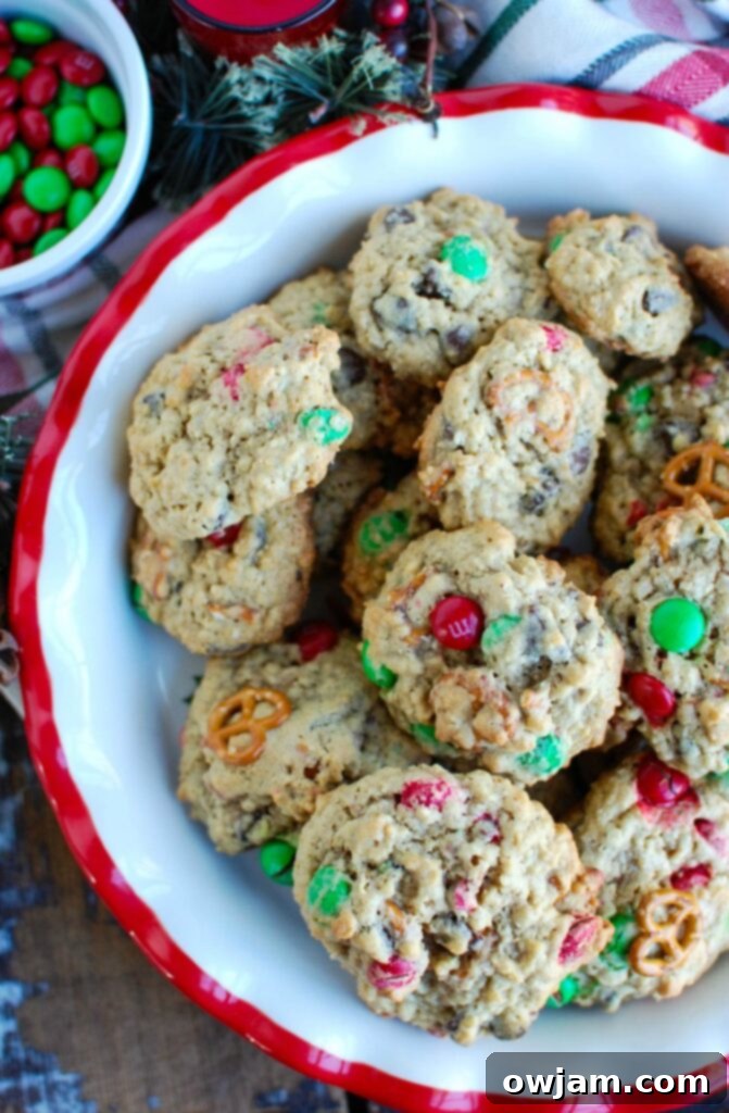 Freshly baked Peanut Butter Pretzel Chocolate Chip Cookies cooling on a wire rack, with some cookies showing a slight golden brown edge and a soft, inviting center.
