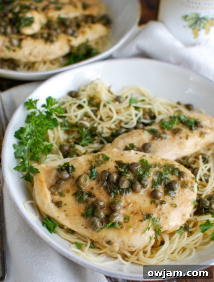 Zesty Lemon Caper Chicken 2 Classic Chicken Piccata served in a white bowl, garnished with fresh parsley.