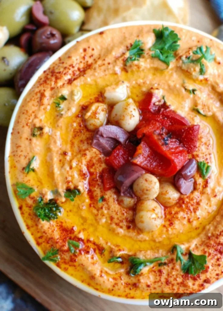 Roasted Red Pepper Greek Yogurt Hummus is a creamy dip that pairs nicely with pita bread or fresh vegetables. Chickpeas, tahini, lemon juice, spices and fire roasted red peppers are blended with Greek yogurt for added protein and creaminess making this not only healthy, but delicious!