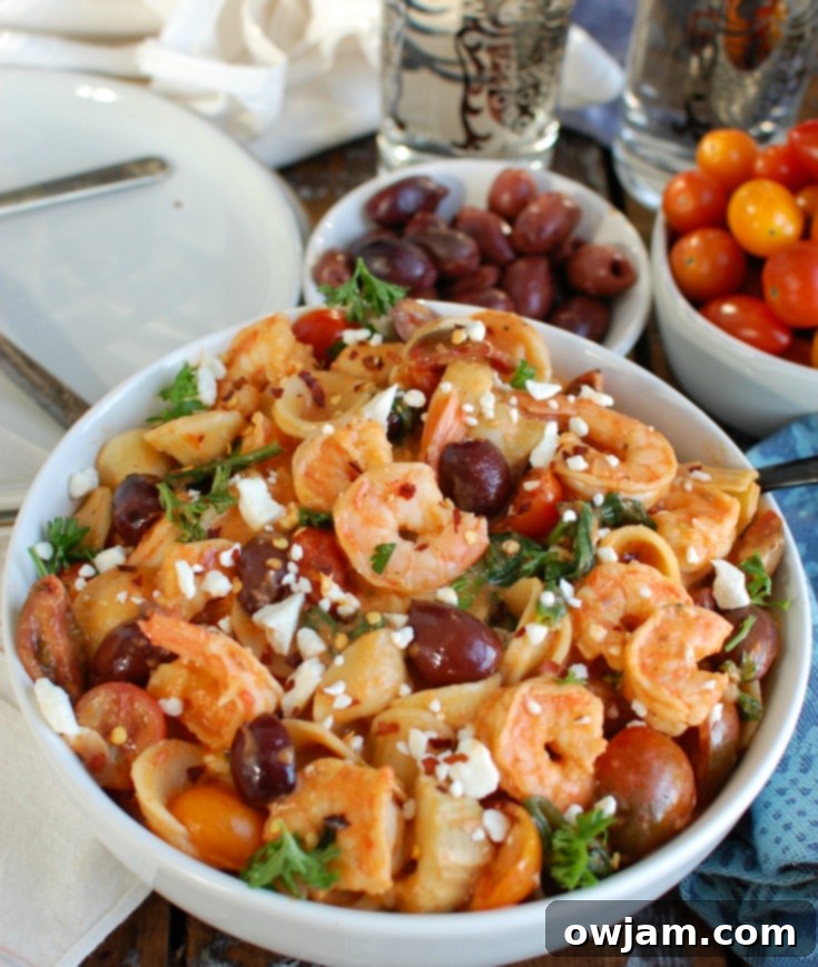 Easy One-Pot Mediterranean Shrimp Pasta 5 A close-up shot of the One Pot Mediterranean Shrimp Pasta in a white bowl, showing the creamy sauce and vibrant ingredients.