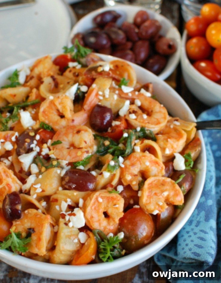 Easy One-Pot Mediterranean Shrimp Pasta 6 Serving of One Pot Mediterranean Shrimp Pasta in a white bowl with a fork.