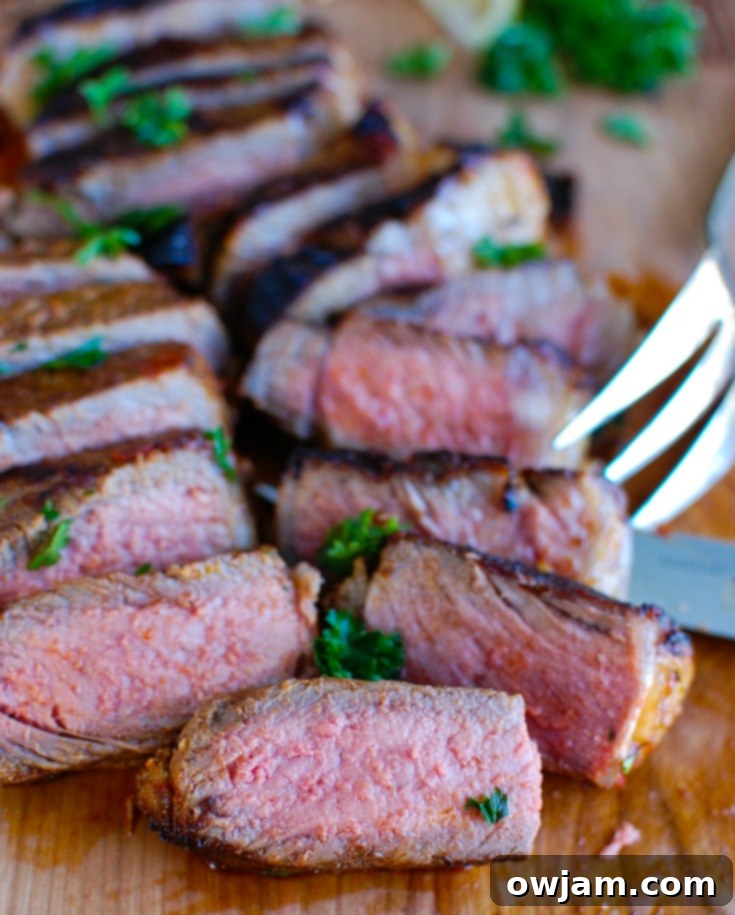 Raw New York Strip steaks coated in a rich harissa marinade, ready for pan-searing, highlighting the vibrant colors of the marinade ingredients.