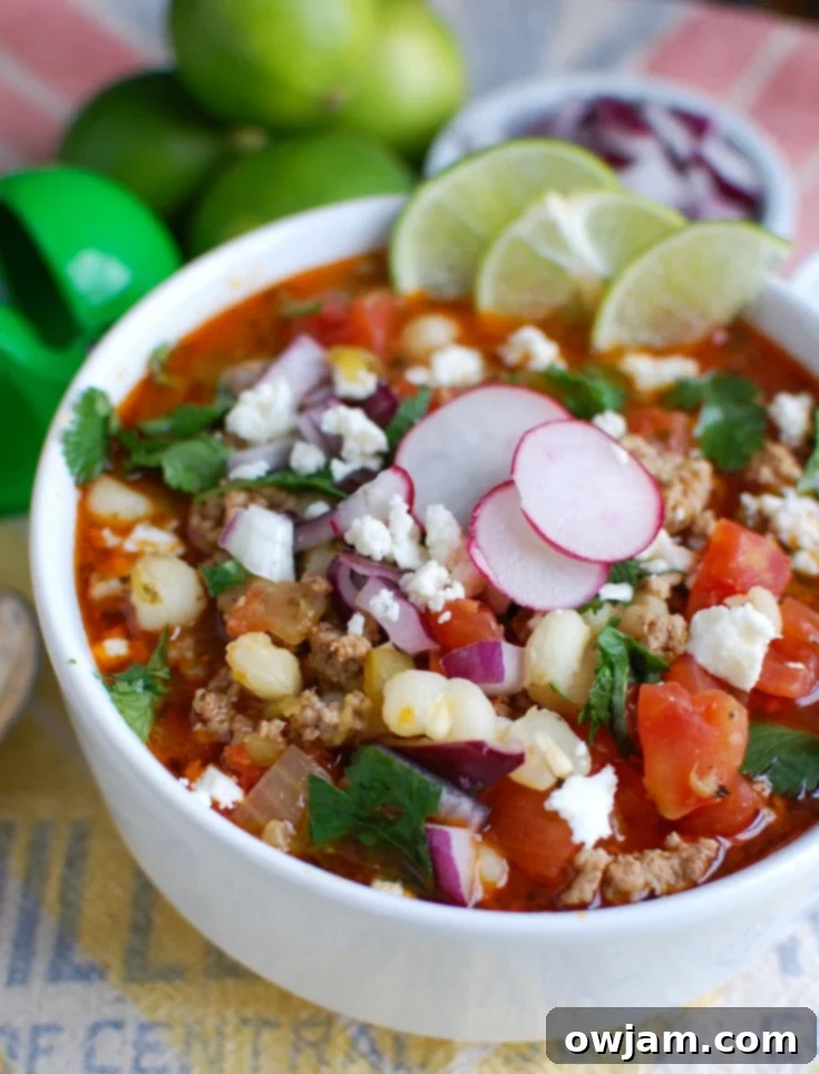A bowl of Slow Cooker Pork Pozole garnished with fresh cilantro and radishes, ready to be served.